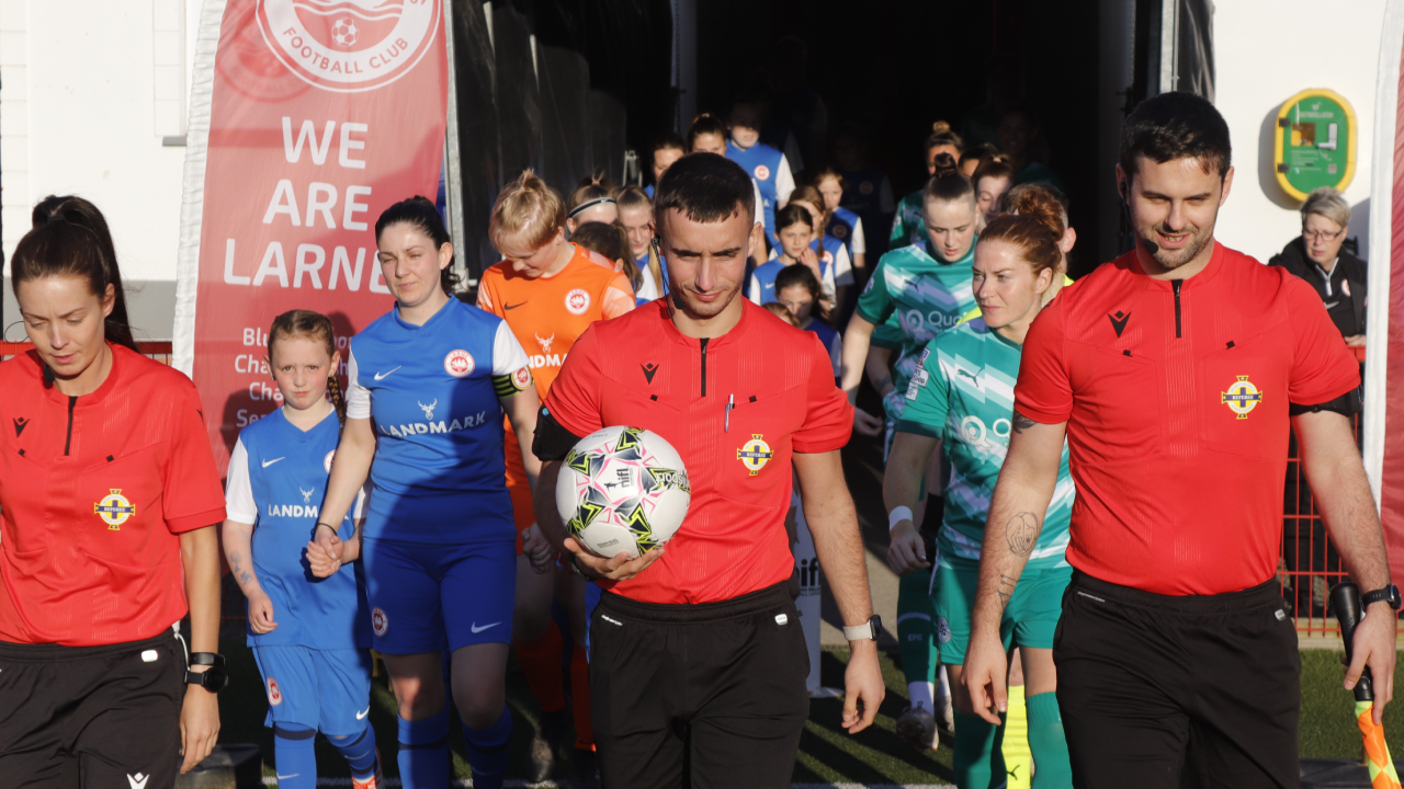 Larne Women and Cliftonville Ladies walking out onto Inver Park.